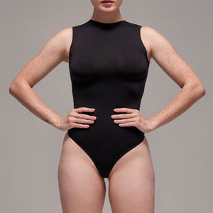Modelo usando body sin manga cuello alto para mujer color negro de Lunia, vista frontal.