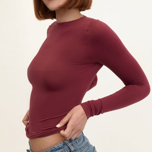 Modelo usando camiseta manga larga cuello alto para mujer color vinotinto de Lunia, vista lateral