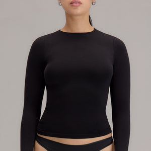 Modelo usando camiseta manga larga cuello alto para mujer color negro de Lunia, vista frontal