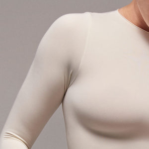 Modelo usando body manga larga cuello alto para mujer color marfil de Lunia, detalle tela cuello.  
