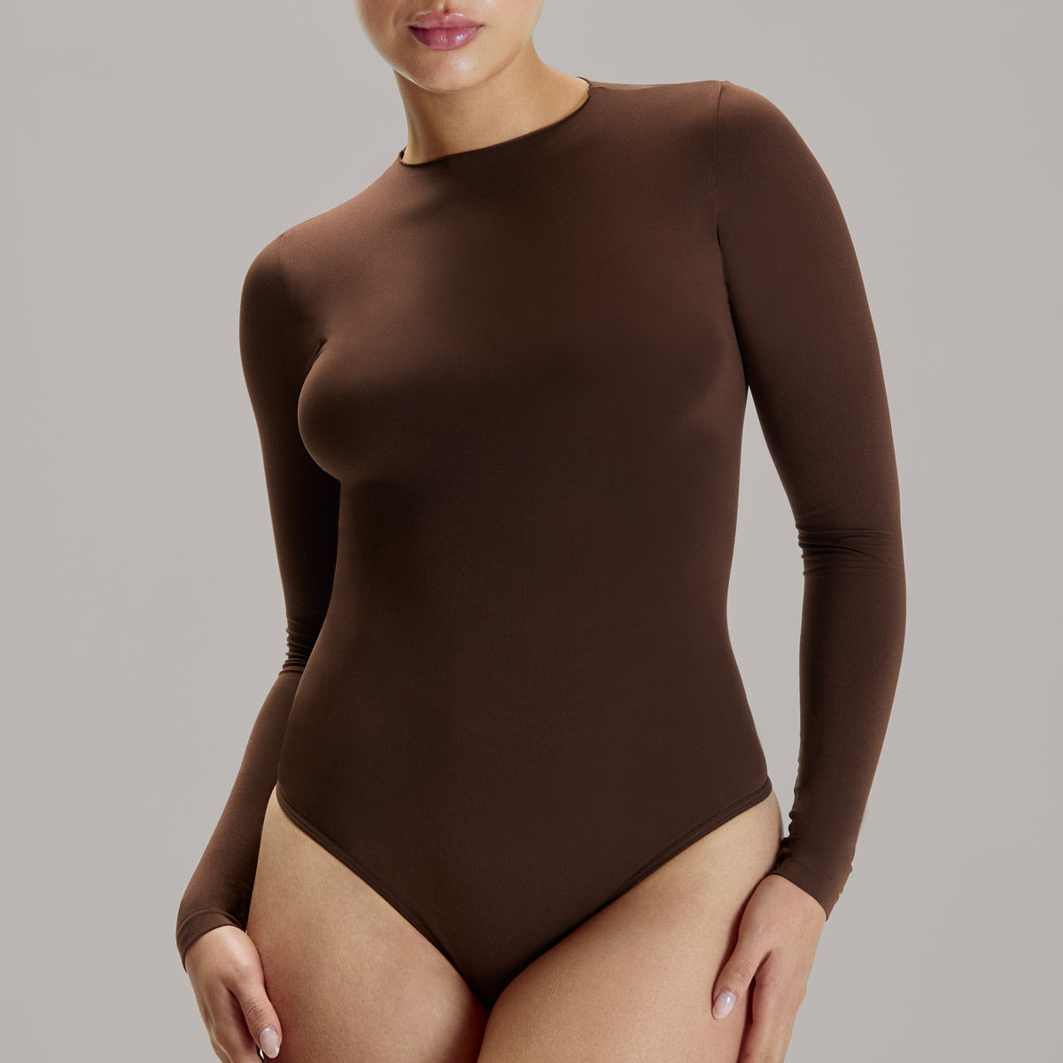 Modelo usando body manga larga cuello alto para mujer color chocolate de Lunia, vista frontal.  