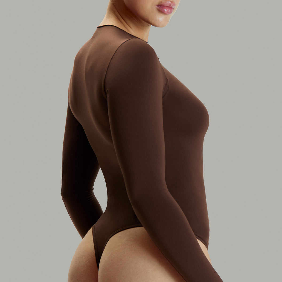 Modelo usando body manga larga cuello alto para mujer color chocolate de Lunia, vista trasera.  