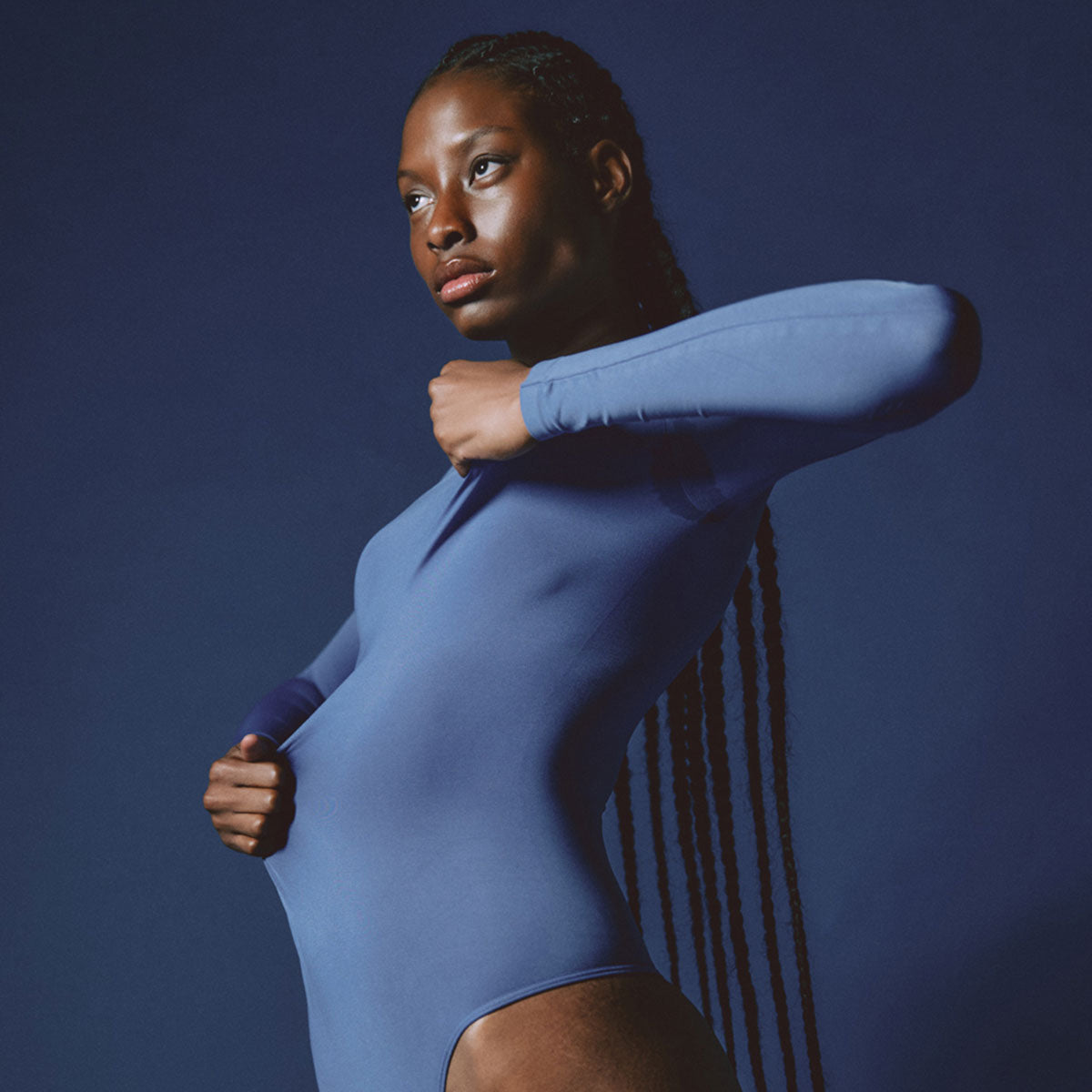 Modelo usando body manga larga cuello alto para mujer color azul fuerza de Lunia vista delantera 