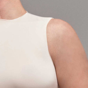 Modelo usando body sin manga cuello alto para mujer color marfil de Lunia, vista cuello. 