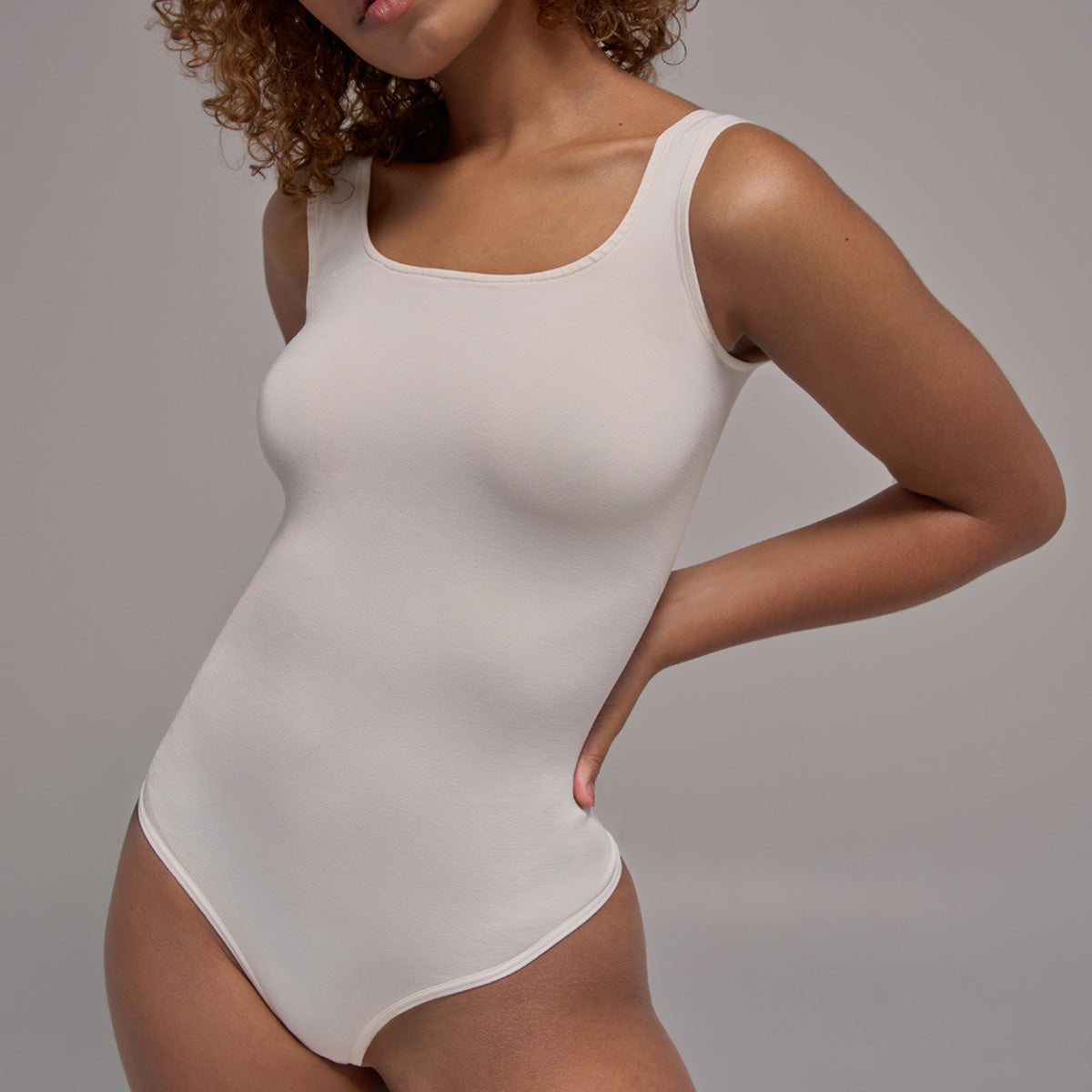 Modelo usando body sin manga cuello redondo para mujer color blanco de Lunia, vista frontal. 