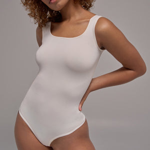Modelo usando body sin manga cuello redondo para mujer color blanco de Lunia, vista frontal. 