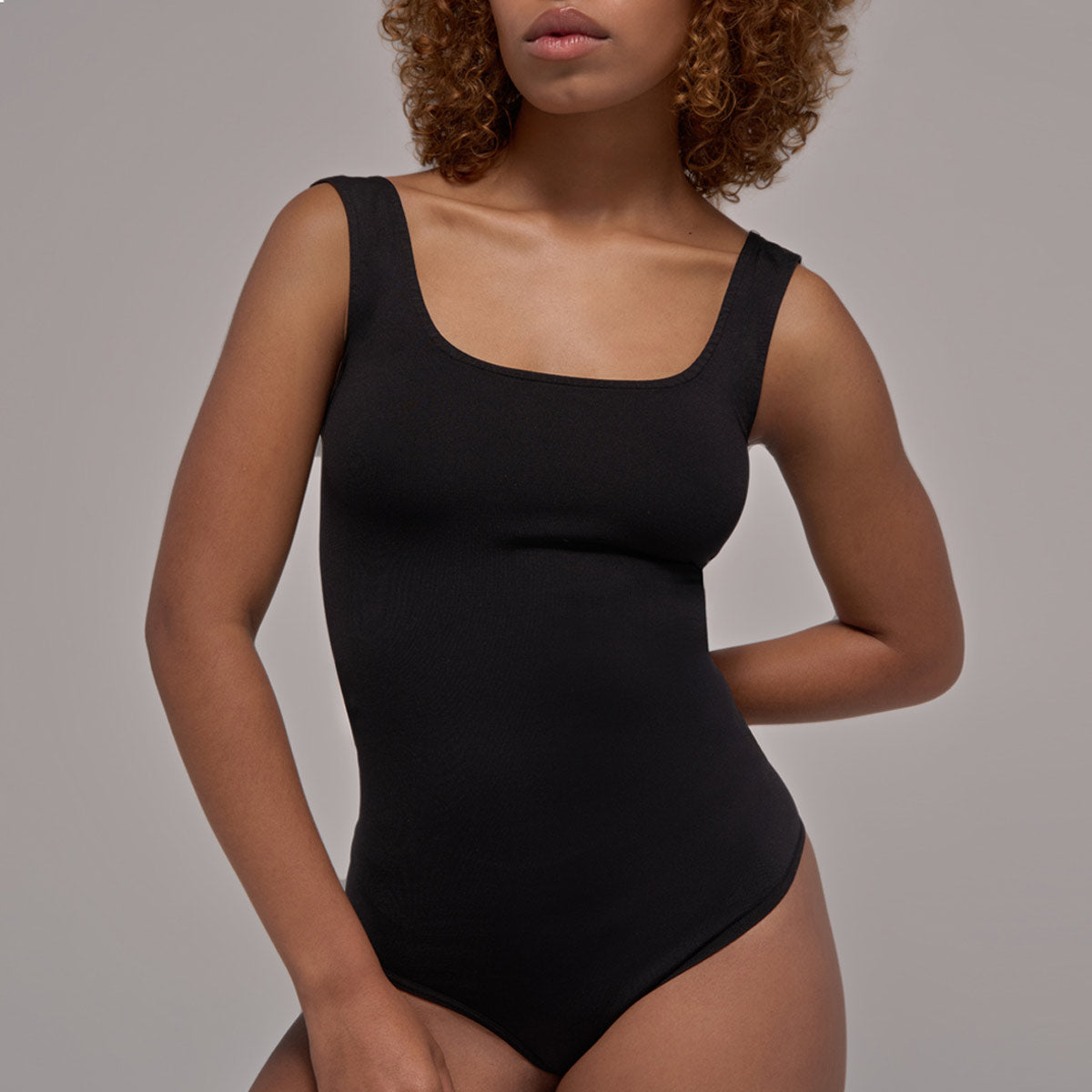 Modelo usando body sin manga cuello redondo para mujer color negro de Lunia, vista frontal. 